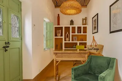 a room with a green door and a table and a chair at Riad Amaya in Marrakech