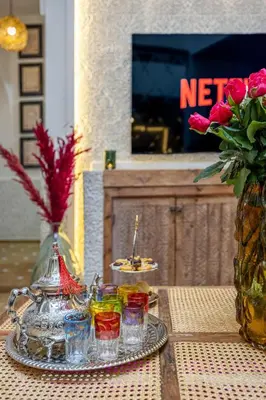 a table with a plate of food and a vase with flowers at Riad Dar Catalia-Exclusive&HeatedPool-FreeBreakfas in Marrakech