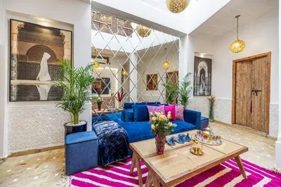 a living room with a blue couch and a table at Riad Dar Catalia-Exclusive&HeatedPool-FreeBreakfas in Marrakech