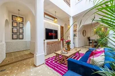 a living room with a blue couch and a table at Riad Dar Catalia-Exclusive&HeatedPool-FreeBreakfas in Marrakech