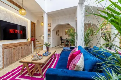 a living room with a blue couch and a table at Riad Dar Catalia-Exclusive&HeatedPool-FreeBreakfas in Marrakech