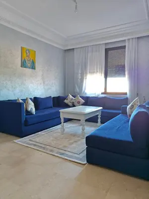 a living room with blue couches and a table at Séjour Familial à Marrakech in Marrakech