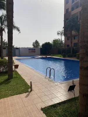 a large swimming pool next to a building at Séjour Familial à Marrakech in Marrakech