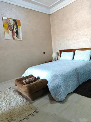 a bedroom with a bed with a blue blanket and a couch at Séjour Familial à Marrakech in Marrakech