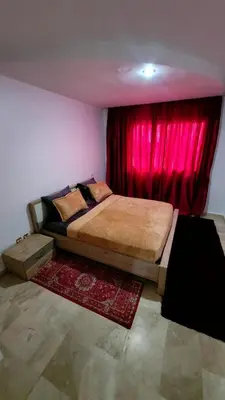 a bedroom with a bed with a red curtain at Le stratégique a 10mn de l'aéroport face gare Ctm Hivernage in Marrakech