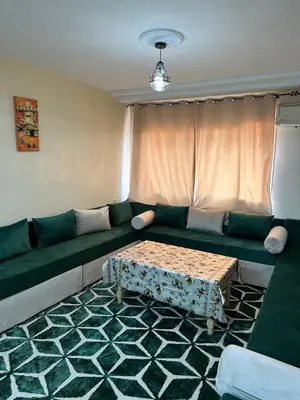 a living room with a green couch and a table at Le stratégique a 10mn de l'aéroport face gare Ctm Hivernage in Marrakech