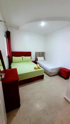 a room with two beds and a couch and a table at Le stratégique a 10mn de l'aéroport face gare Ctm Hivernage in Marrakech