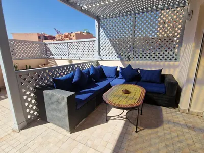 a balcony with a blue couch and a table at appartement hyper centre Gueliz in Marrakech