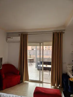 a living room with a red couch and a sliding glass door at appartement hyper centre Gueliz in Marrakech