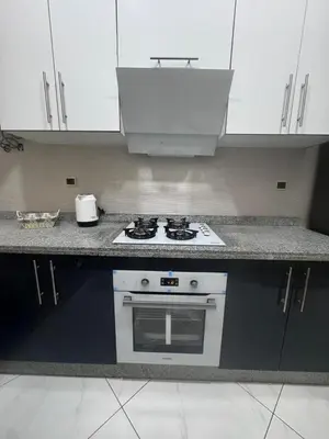 a kitchen with a white stove and white cabinets at IMMOB Basma in Marrakech