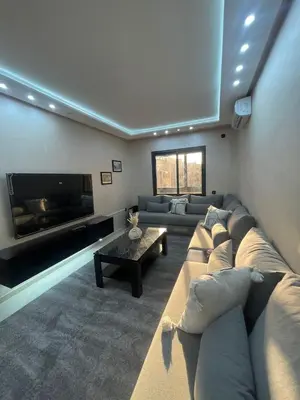a living room with a large couch and a tv at IMMOB Basma in Marrakech
