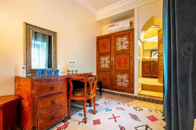 a room with a wooden desk and a mirror at Riad Kamal Deluxe in Marrakech