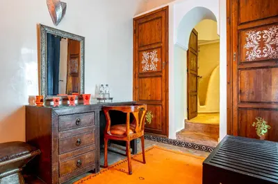 a bathroom with a wooden dresser and a mirror at Riad Kamal Deluxe in Marrakech