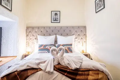 two towelcovered swans are sitting on a bed at Riad Kamal Deluxe in Marrakech