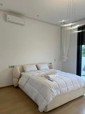 a white bedroom with a large bed and a window at Villa Marrakech karim in Marrakech