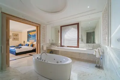 a large bathroom with a tub and a bedroom at Palais Les Orchidées - Villa de Luxe à 15 minutes du Centre in Marrakech