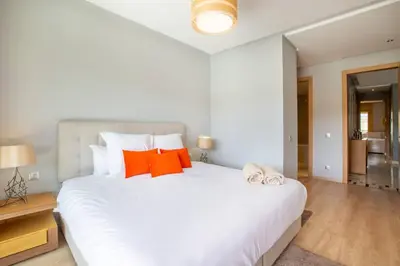 a bedroom with a large white bed with orange pillows at Heavenly Setting at Prestigia Pool in Marrakech