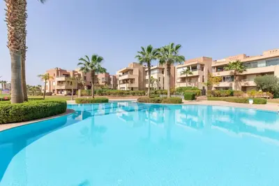 a large swimming pool with palm trees and condos at Heavenly Setting at Prestigia Pool in Marrakech