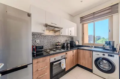 a kitchen with a washing machine and a washer at Serenity and Confort in Prestigia 10 min du centre in Marrakech