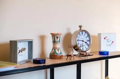 a shelf with a clock and glasses on it at Serenity and Confort in Prestigia 10 min du centre in Marrakech