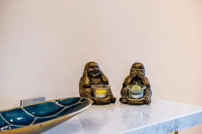 two statues of three monkeys holding candles on a table at Serenity and Confort in Prestigia 10 min du centre in Marrakech