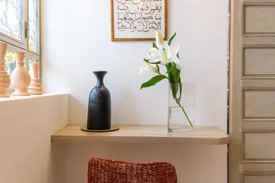 a table with a vase and a vase of flowers on it at Riad Grenade Exclusif Front Bahia in Marrakech