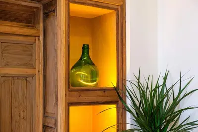 a green glass vase sitting on a shelf next to a mirror at Riad Grenade Exclusif Front Bahia in Marrakech