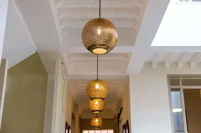 a hallway with three lights hanging from a ceiling at Riad Grenade Exclusif Front Bahia in Marrakech