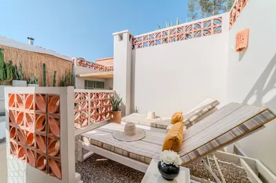 a patio with a wooden bench and a fence at Riad Grenade Exclusif Front Bahia in Marrakech