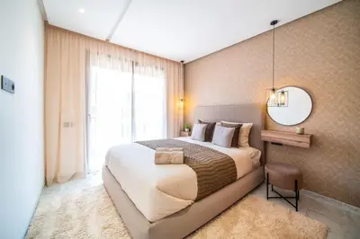 a bedroom with a large bed and a large window at Cute and Modern in Heart of Downtown in Marrakech