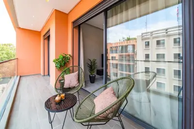 a balcony with two chairs and a table at Cute and Modern in Heart of Downtown in Marrakech