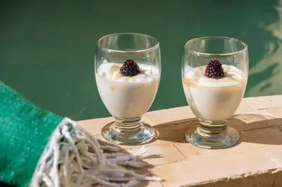 two glasses of milk pudding with a blackberry on top at Riad Ines 10mn to Place with Breakfast in Marrakech