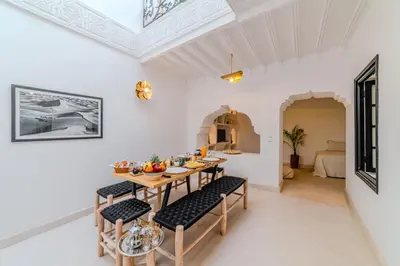 a dining room with a wooden table and chairs at Riad Ines 10mn to Place with Breakfast in Marrakech