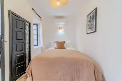 a bedroom with a bed in a white room at Riad Ines 10mn to Place with Breakfast in Marrakech