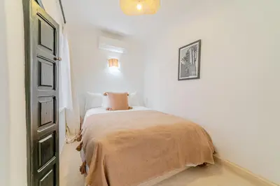 a bedroom with a bed with a blanket on it at Riad Ines 10mn to Place with Breakfast in Marrakech