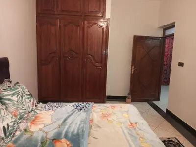 a bedroom with a bed and a wooden cabinet at Spacious Apt - Near Airport - Perfect for Groops! in Marrakech