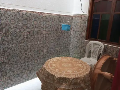 a room with a table and a chair and a wall at Spacious Apt - Near Airport - Perfect for Groops! in Marrakech