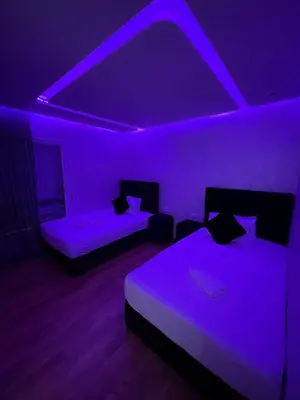 a bedroom with two beds and a purple lighting at Luxury Appartement in Marrakech