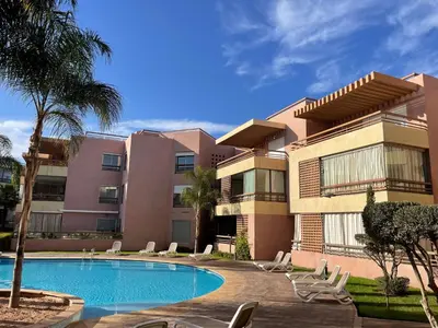 an apartment building with a swimming pool and chairs at Luxury Appartement in Marrakech
