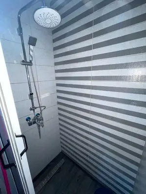 a shower in a bathroom with a striped wall at Appartement Zen in Marrakech
