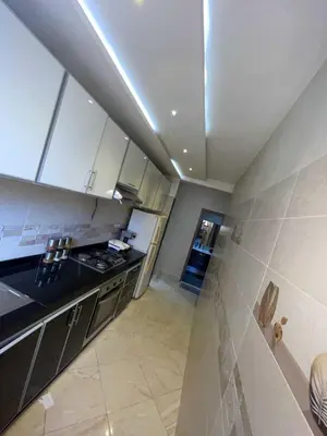 a kitchen with white cabinets and a sink and a stove at Appartement Zen in Marrakech
