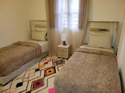 a bedroom with two beds and a rug at Authentic stay 2 in Marrakech Comfort & Charm in Marrakech