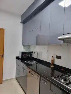 a kitchen with white cabinets and a black counter top at Appartement a les portes de gueliz in Marrakech