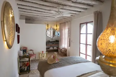 a bedroom with a bed and a large window at Le Singe Rose & SPA in Marrakech