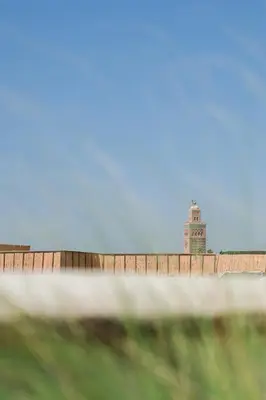 a fence with a lighthouse in the background at Le Singe Rose & SPA in Marrakech