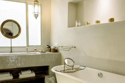a bathroom with a tub and a sink and a mirror at Le Singe Rose & SPA in Marrakech