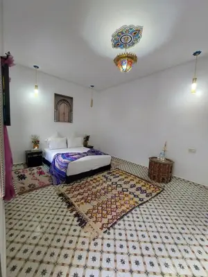 a bedroom with a bed and a rug on the floor at Riad Zaid in Marrakech
