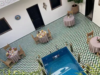 an aerial view of a room with two tables and a pool at Riad Zaid in Marrakech