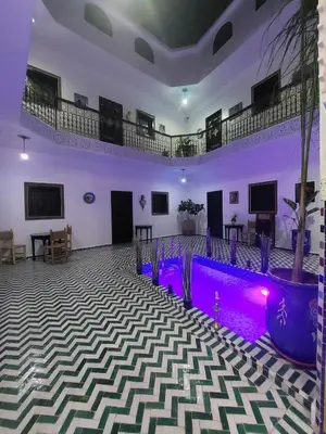 a large room with purple lighting and a stage at Riad Zaid in Marrakech