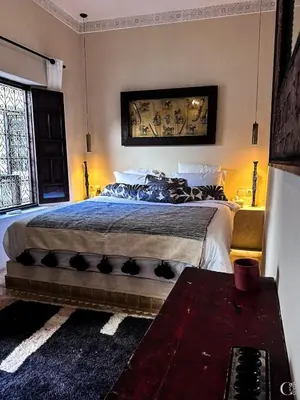 a bedroom with a bed with a blue comforter at Riad des Sources in Marrakech
